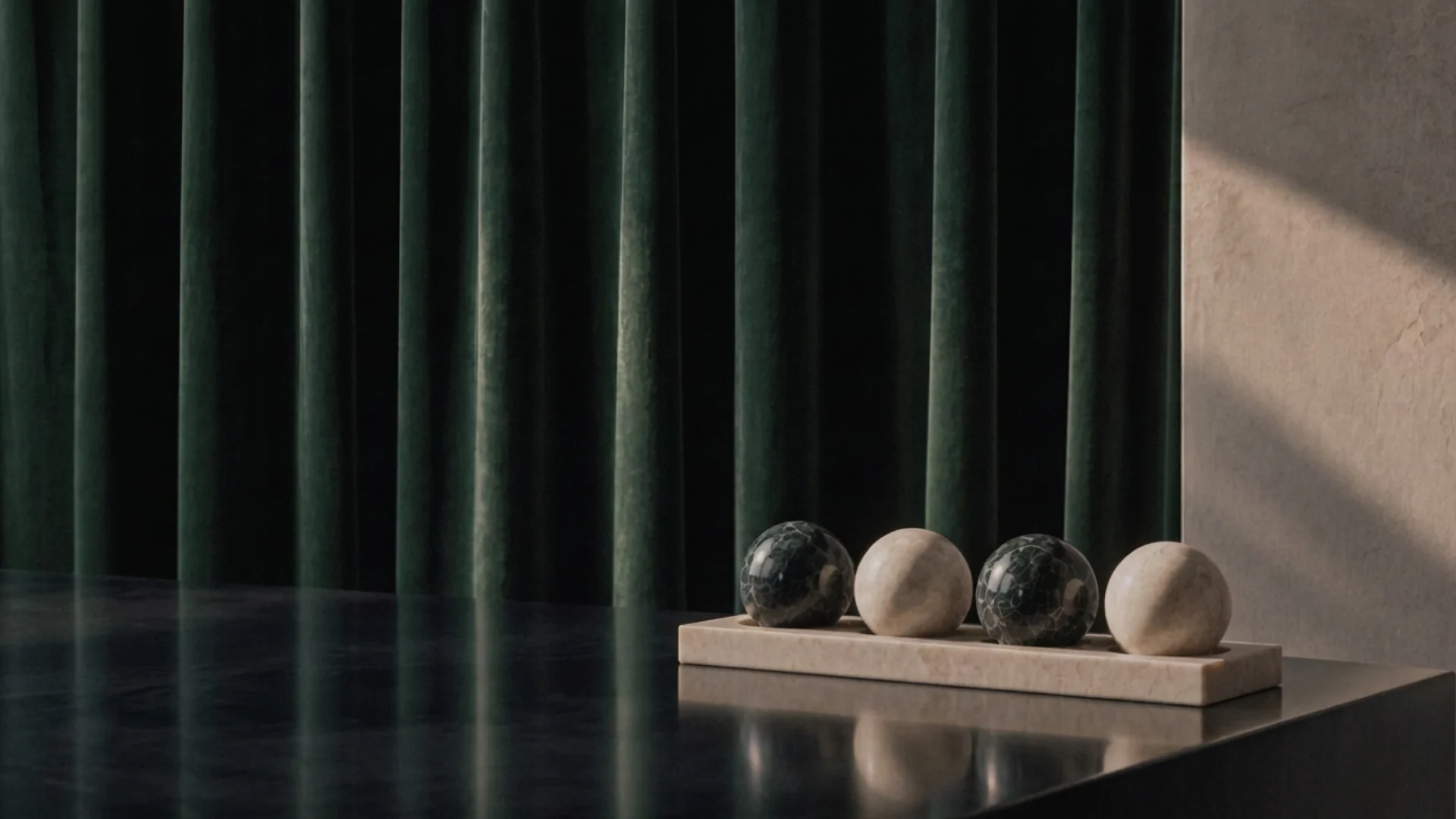 Green and white marble spheres on a stone tray before a deep green velvet curtain.